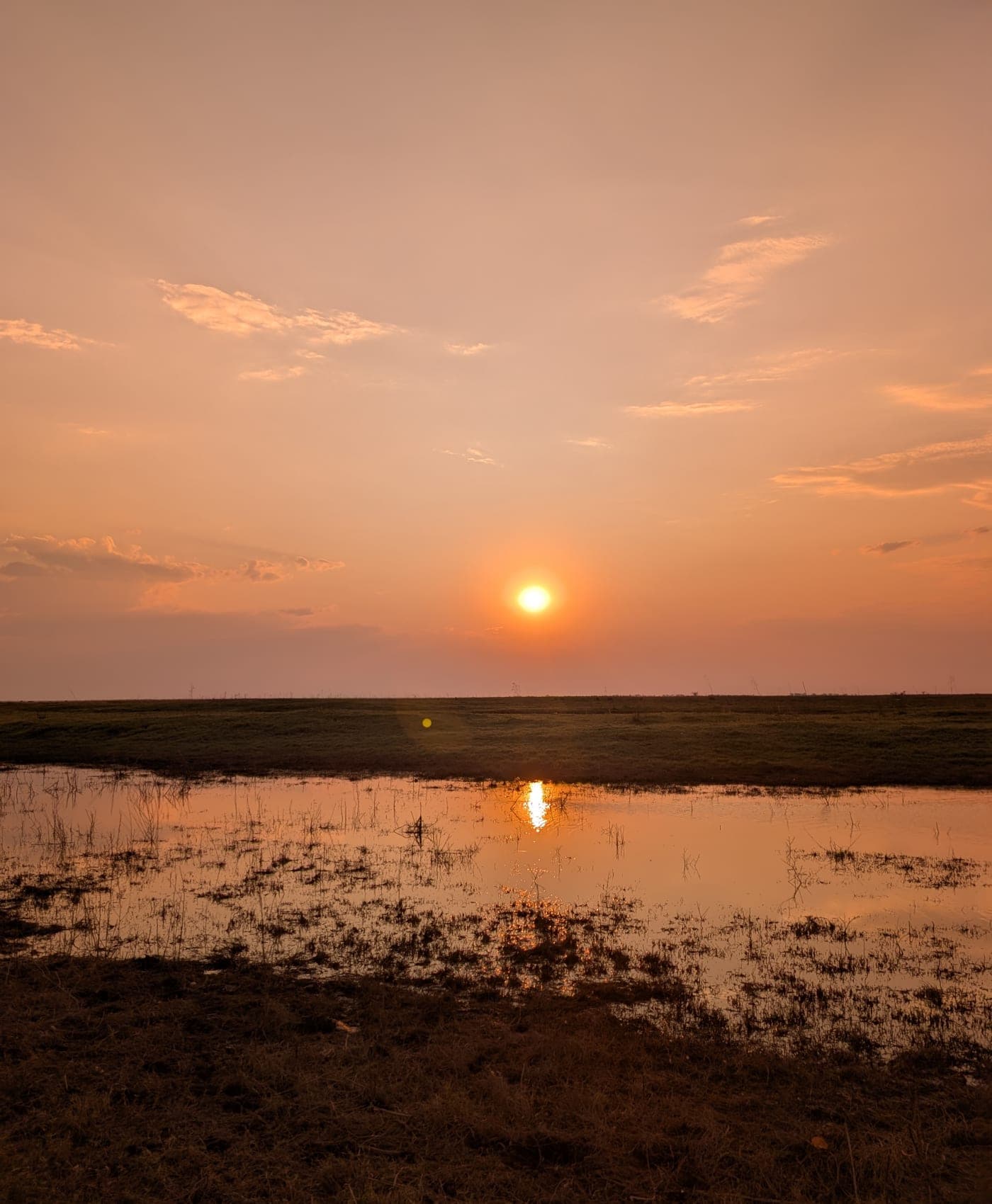 Coucher de soleil sur les plaines inondables, le ciel se reflétant dans l’eau